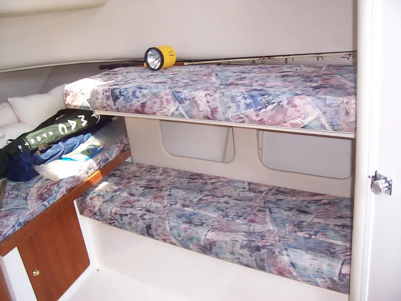 Slide: The Image of 1999 Shamrock 290 Walkaround cabin interior with bunk beds and storage. - 3
