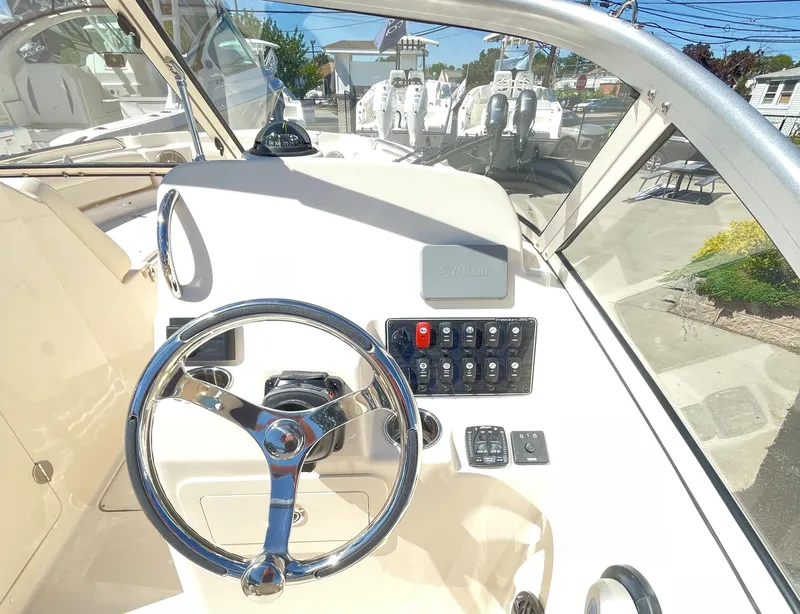 Slide: The Image of 2025 Grady-White Freedom 215 boat dashboard with steering wheel and control panel. - 5