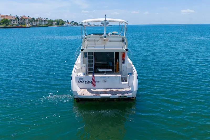 Slide: The Image of 1998 Azimut 43 Fly yacht on calm blue water, rear view. - 11