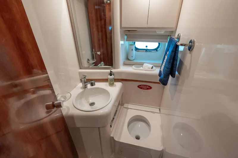 Slide: The Image of Bathroom interior of 1998 Azimut 43 Fly yacht, featuring sink, toilet, and window. - 31