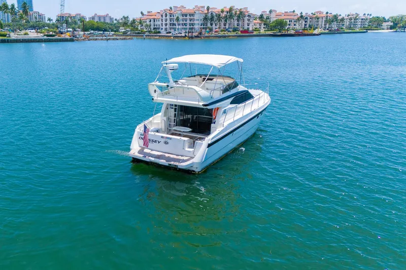 Slide: The Image of Azimut 43 Fly 1998 yacht on calm water with scenic coastal backdrop. - 7