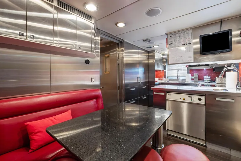 Slide: The Image of 2008 Palmer Johnson 120 Sports Cruiser kitchen with stainless steel appliances and red seating. - 38