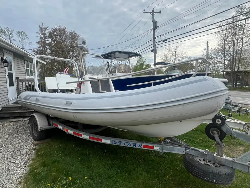 Slide: The Image of 2004 AB 570 VST inflatable boat on a trailer in a residential yard. - 2