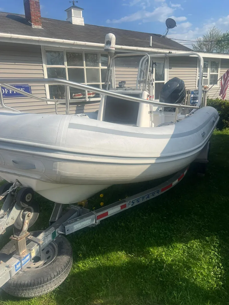 Slide: The Image of 2004 AB 570 VST inflatable boat on a trailer in front of a house. - 5