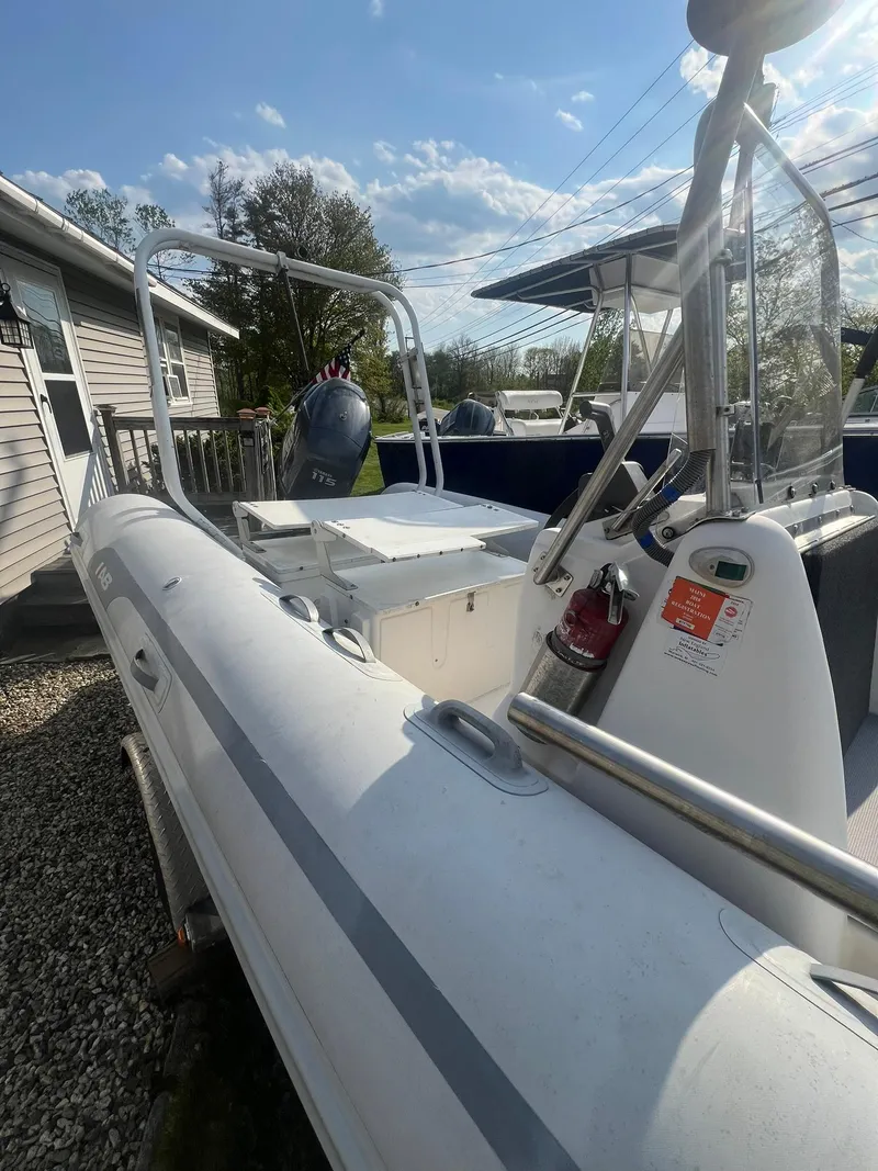 Slide: The Image of 2004 AB 570 VST inflatable boat with outboard motor, docked near a house. - 9