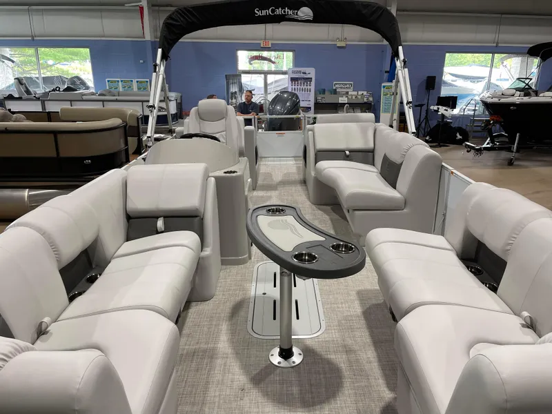 Slide: The Image of 2024 SunCatcher Fusion 324SS pontoon boat interior with plush seating and table. - 9