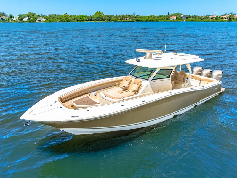 Slide: The Image of 2018 Scout 380 LXF luxury boat cruising on a serene blue lake. - 2