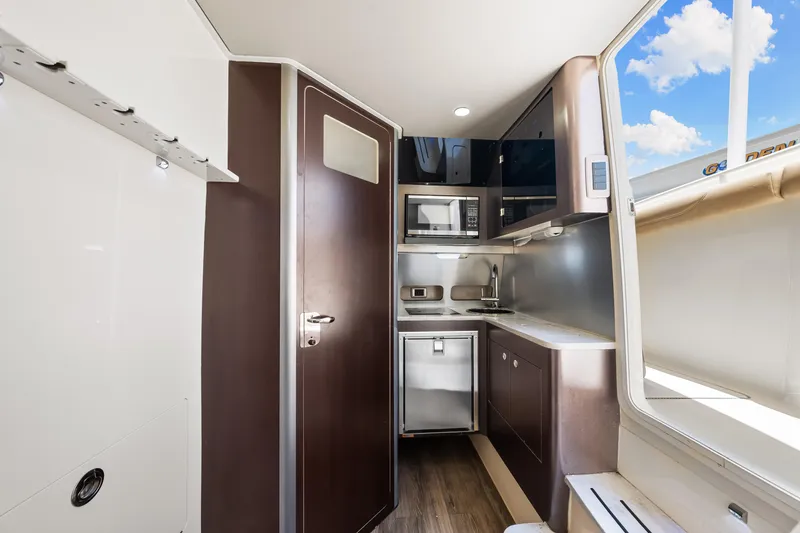 Slide: The Image of 2018 Scout 380 LXF boat interior kitchen with modern appliances and wood finish. - 38
