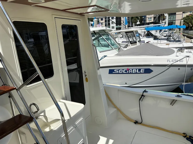 Slide: The Image of 2004 Sabreline 36 Sedan yacht docked at marina, view of cockpit and neighboring boats. - 20