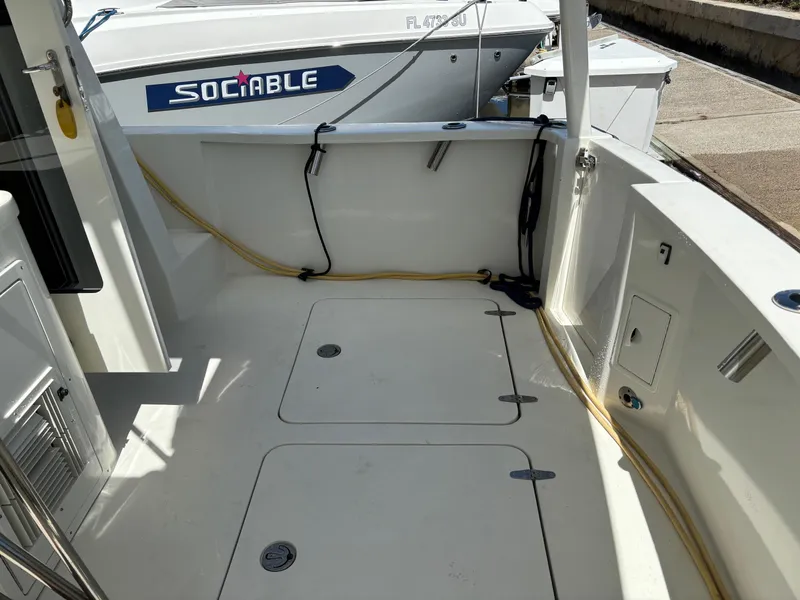 Slide: The Image of 2004 Sabreline 36 Sedan boat deck with storage hatches and docked nearby vessel. - 23