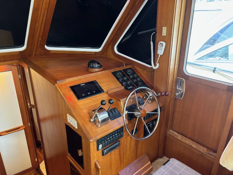 Slide: The Image of 2004 Sabreline 36 Sedan helm station with wooden finish and navigation controls. - 28