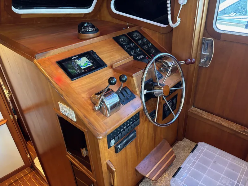 Slide: The Image of 2004 Sabreline 36 Sedan helm station with navigation equipment and wooden steering wheel. - 29