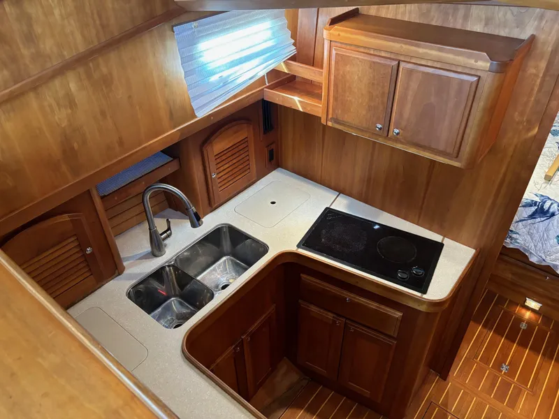 Slide: The Image of 2004 Sabreline 36 Sedan kitchen with wooden cabinets, dual sink, and stovetop. - 42