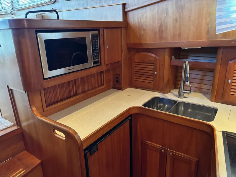 Slide: The Image of 2004 Sabreline 36 Sedan kitchen with microwave, sink, and wooden cabinetry. - 44