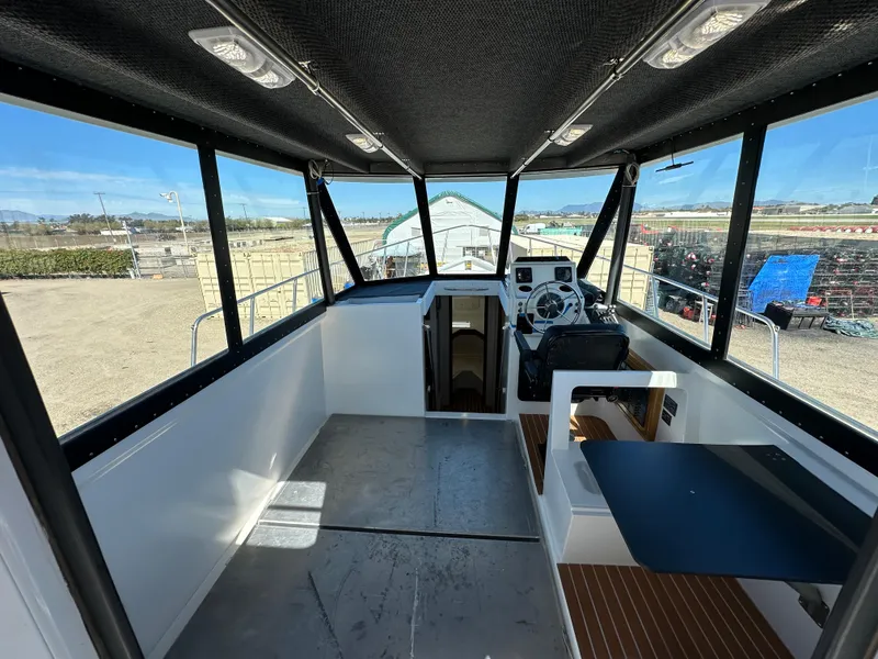 Slide: The Image of Interior of a 1992 Custom Hueneme Boat Works vessel with steering console and seating area. - 18
