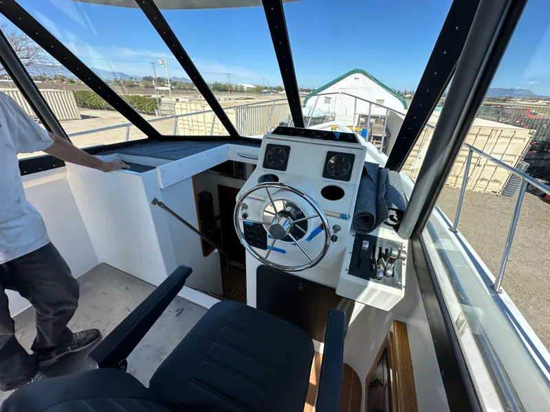 Slide: The Image of 1992 Custom Hueneme Boat Works helm station with steering wheel and controls. - 22