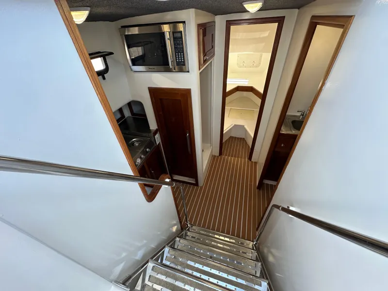 Slide: The Image of Interior of a 1992 Custom Hueneme Boat Works, featuring a kitchenette and sleeping quarters. - 26