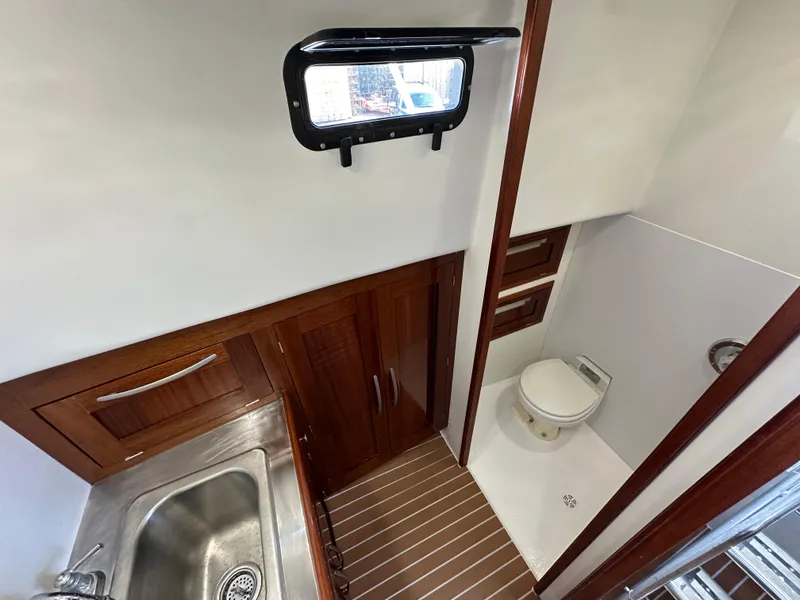 Slide: The Image of 1992 Custom Hueneme Boat Works bathroom with sink, wooden cabinets, and toilet. - 30