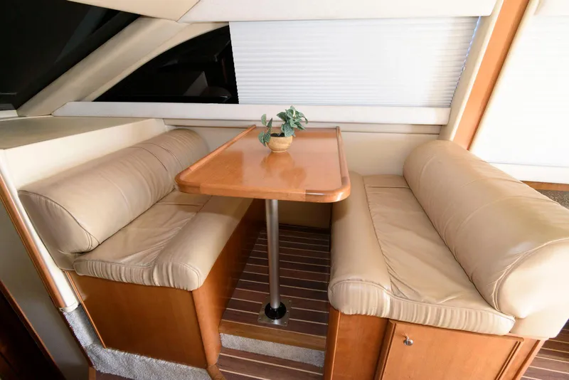 Slide: The Image of Luxurious seating area in 2003 Meridian 381 Sedan yacht with wooden table and beige cushions. - 11