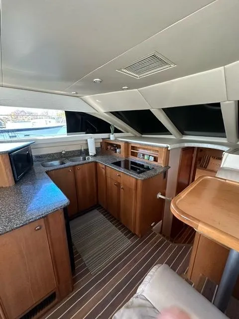 Slide: The Image of 2003 Meridian 381 Sedan yacht interior with modern kitchen and wooden cabinetry. - 14