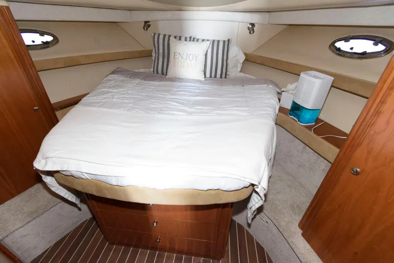Slide: The Image of Cozy bedroom interior of 2003 Meridian 381 Sedan yacht with striped pillow and portholes. - 16