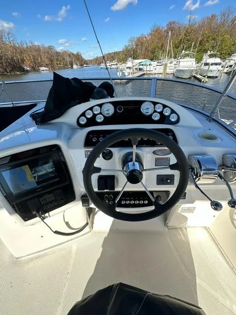 Slide: The Image of 2003 Meridian 381 Sedan boat helm with gauges and navigation system on a sunny day. - 8