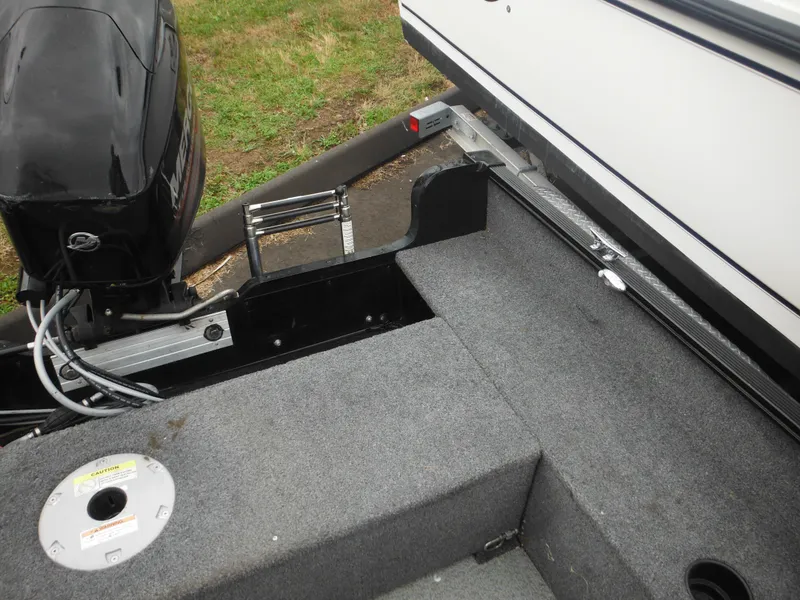 Slide: The Image of 2018 Lund 1625 Fury XL SS boat interior with motor and carpeted deck. - 28