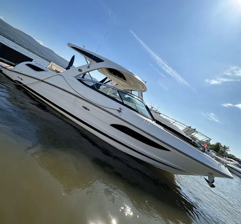 Slide: The Image of 2014 Sea Ray 350 SLX boat on calm water under clear blue sky. - 1
