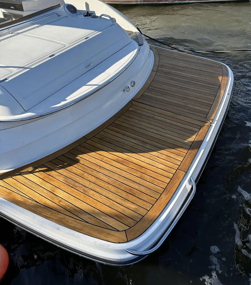 Slide: The Image of 2014 Sea Ray 350 SLX boat with teak swim platform on calm water. - 13