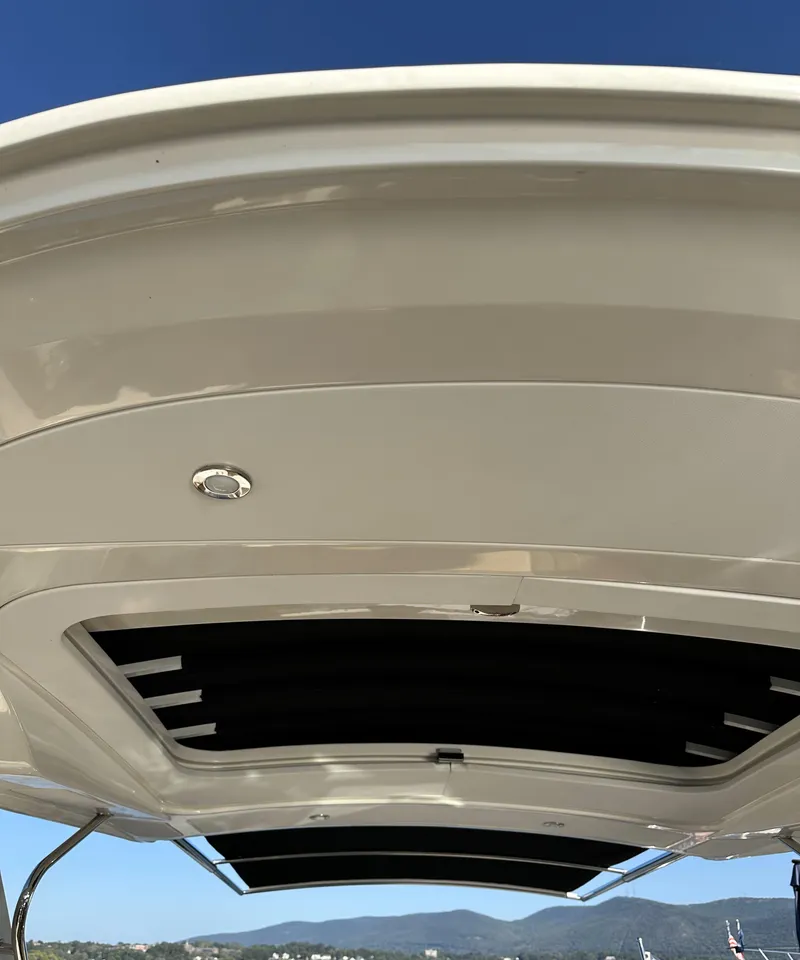 Slide: The Image of 2014 Sea Ray 350 SLX boat roof with open sunroof against clear blue sky. - 16