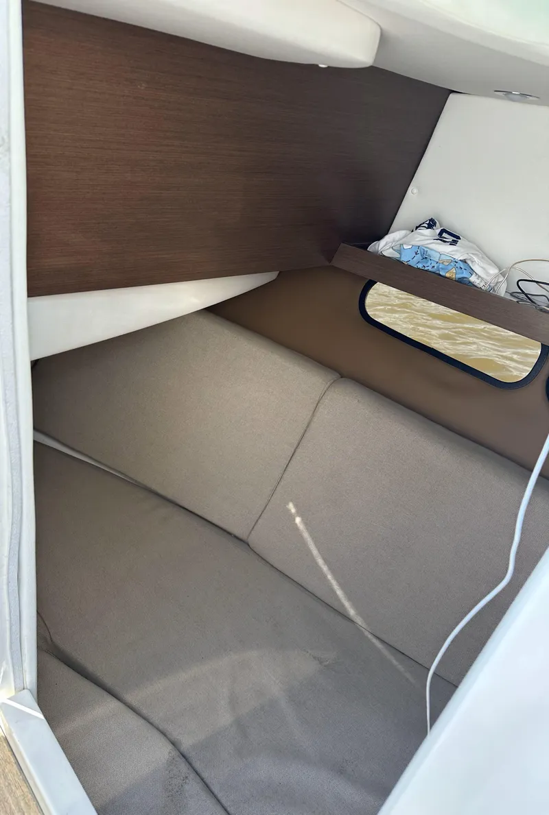 Slide: The Image of Interior cabin of 2014 Sea Ray 350 SLX boat, featuring cozy seating and storage. - 17