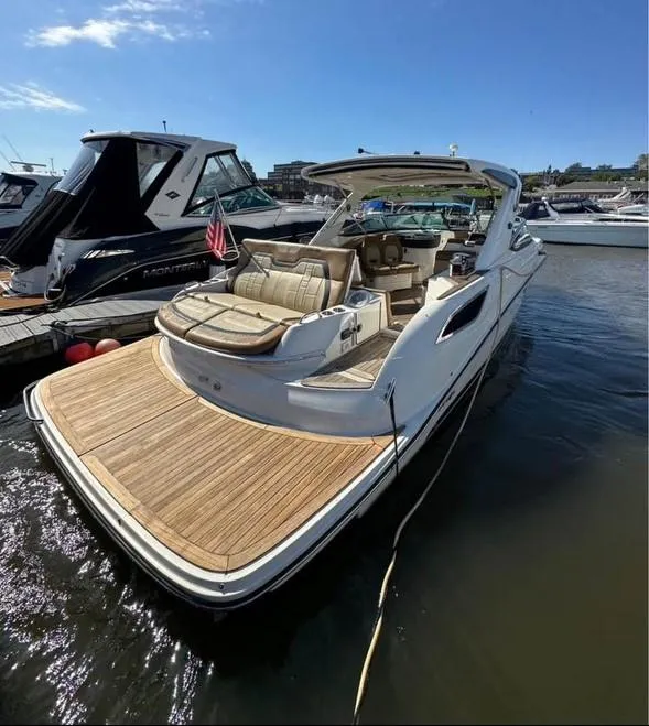 Slide: The Image of 2014 Sea Ray 350 SLX luxury boat docked, featuring spacious seating and sleek design. - 7