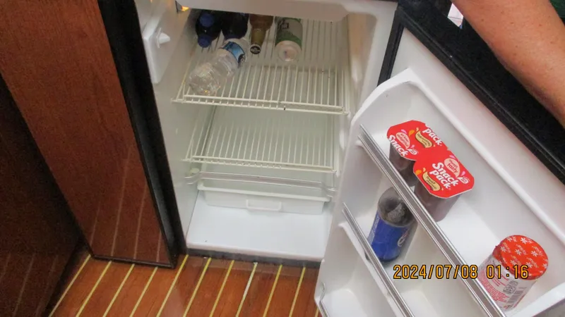 Slide: The Image of Open fridge inside a 2007 Regal 4080 Sportyacht with drinks and snacks. - 21