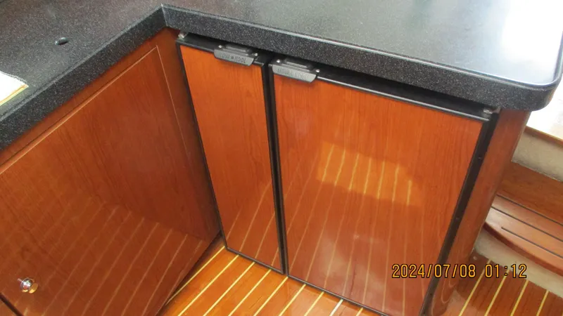 Slide: The Image of Wooden cabinetry and mini fridge in 2007 Regal 4080 Sportyacht kitchen area. - 25