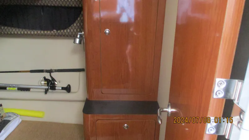 Slide: The Image of Interior of a 2007 Regal 4080 Sportyacht with wooden cabinets and fishing rod. - 20