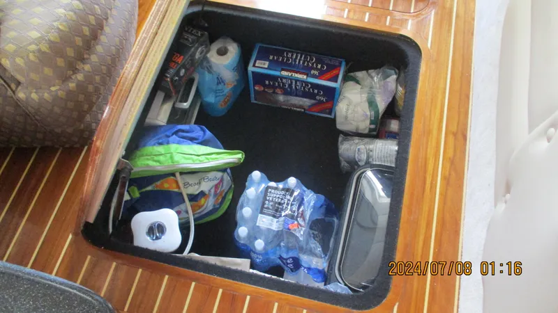 Slide: The Image of Storage compartment in a 2007 Regal 4080 Sportyacht with various supplies and beverages. - 35