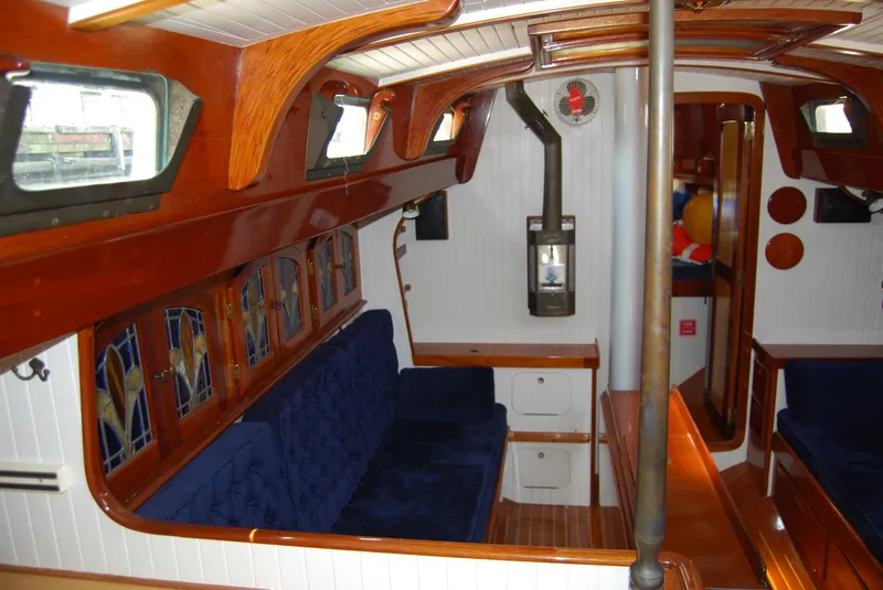 Slide: The Image of Interior of 1983 Cherubini 44 Ketch with wooden finish and blue cushioned seating. - 3