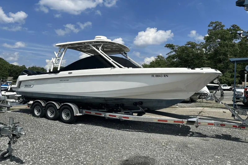 Slide: The Image of 2017 Boston Whaler 270 Vantage boat on trailer under clear sky. - 1