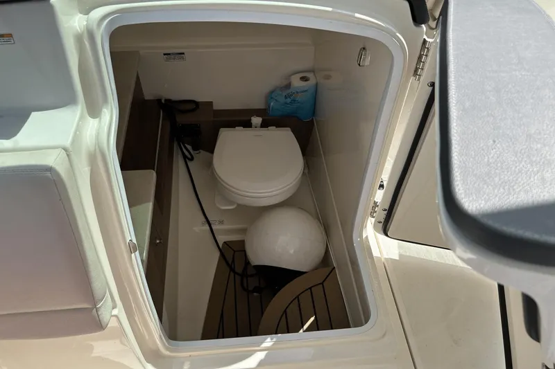 Slide: The Image of Interior of 2017 Boston Whaler 270 Vantage boat showing compact marine toilet. - 16