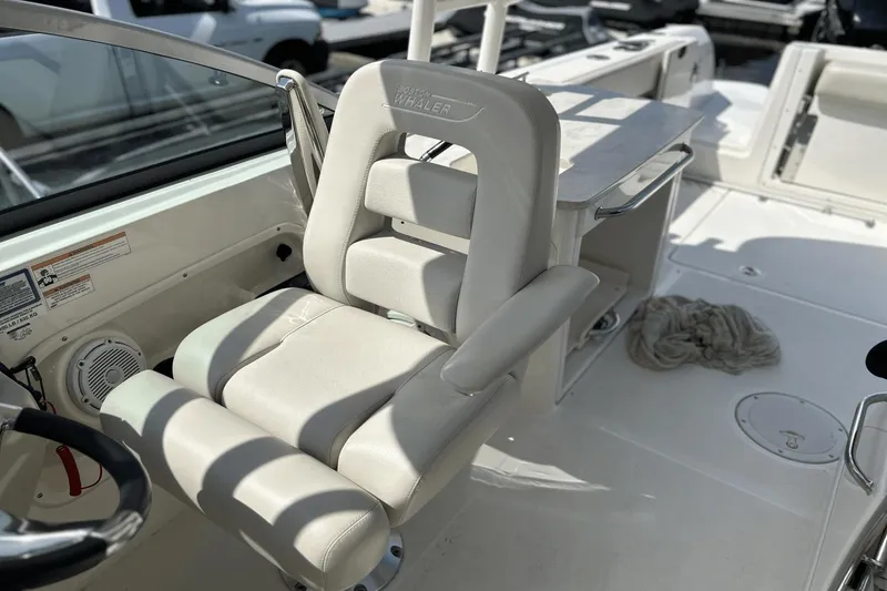 Slide: The Image of 2017 Boston Whaler 270 Vantage boat interior with cushioned seating and steering wheel. - 19