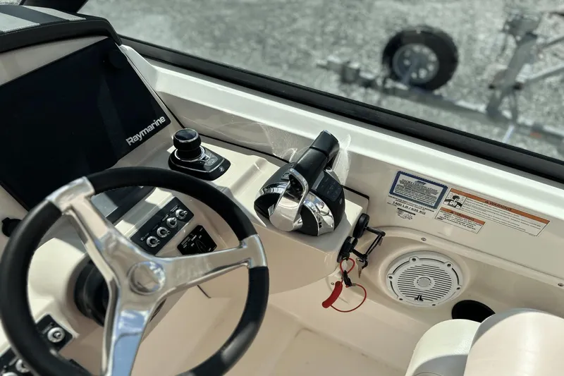 Slide: The Image of 2017 Boston Whaler 270 Vantage helm with steering wheel, controls, and Raymarine display. - 23