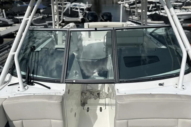 Slide: The Image of 2017 Boston Whaler 270 Vantage boat with windshield and seating, docked at marina. - 26