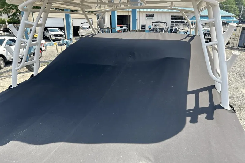 Slide: The Image of 2017 Boston Whaler 270 Vantage boat with black cover in a marina setting. - 36