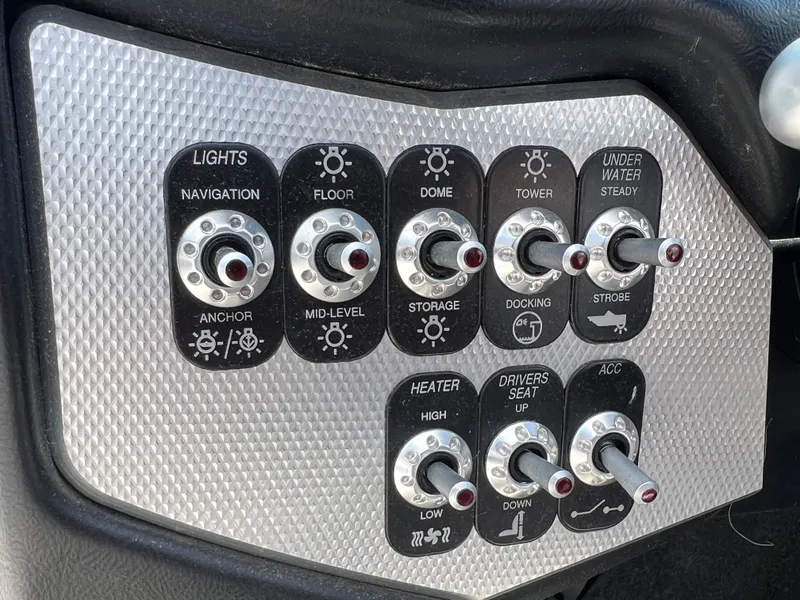 Slide: The Image of Control panel of a 2015 Supra SG 400 boat with various switches for lights and functions. - 26