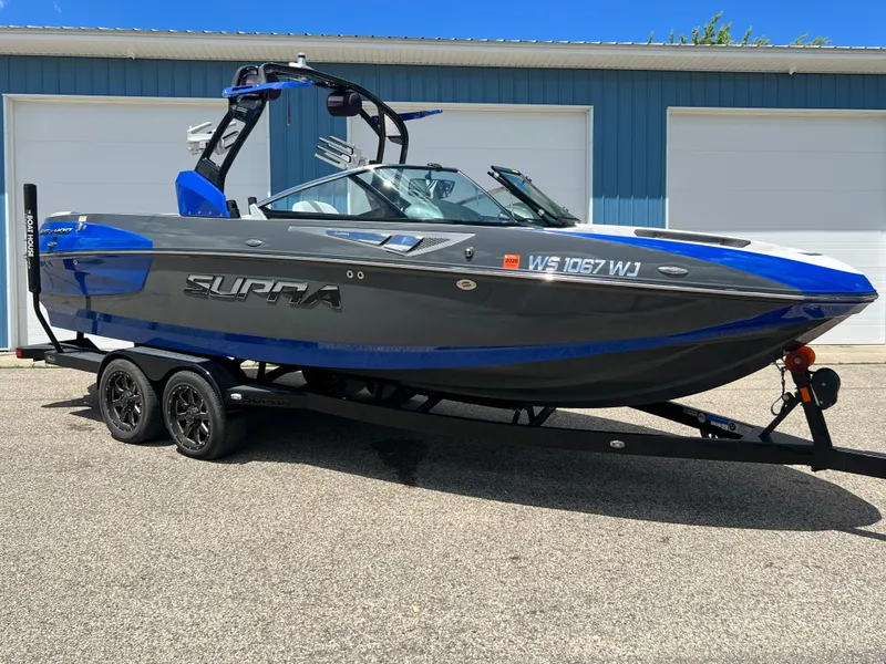Slide: The Image of 2015 Supra SG 400 boat with blue and gray design on a trailer. - 3