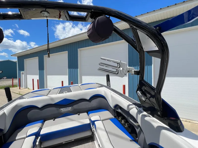 Slide: The Image of 2015 Supra SG 400 boat interior with blue and gray seating, docked near blue building. - 31