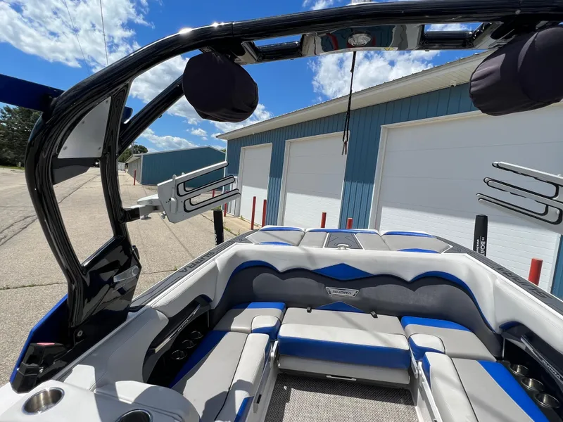 Slide: The Image of 2015 Supra SG 400 boat interior with blue and gray seating, docked near a blue building. - 32