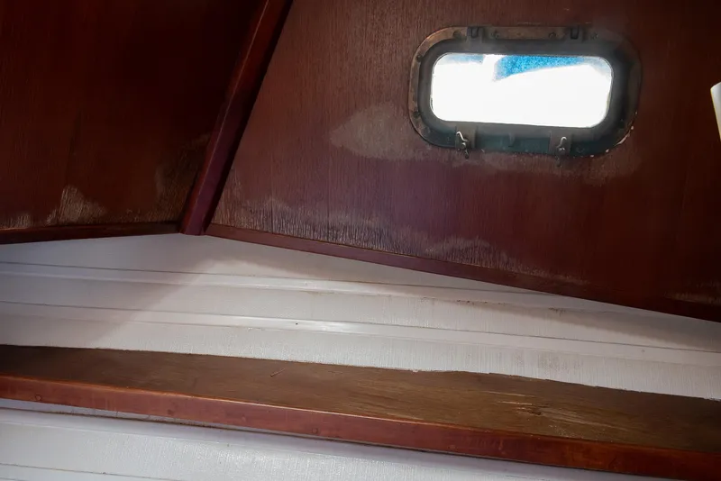 Slide: The Image of Interior view of 1978 CHB Puget Trawler 37 with wooden paneling and porthole. - 17