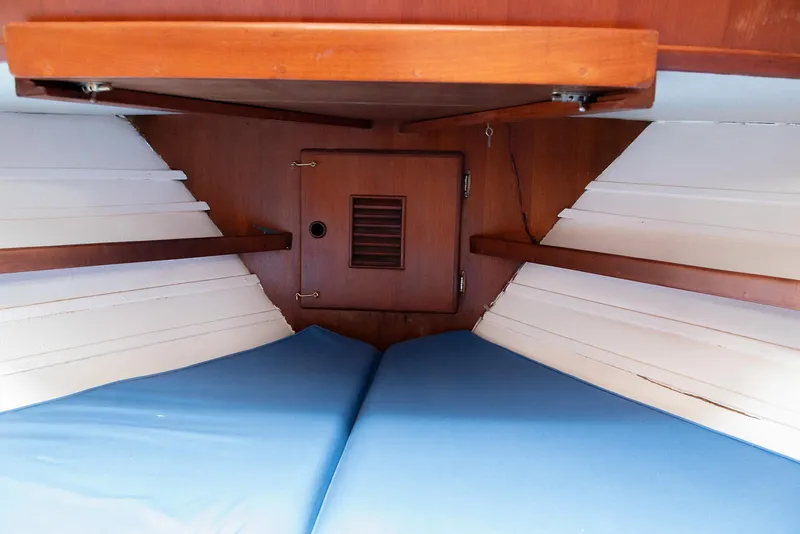Slide: The Image of 1978 CHB Puget Trawler 37 interior cabin with blue cushions and wooden paneling. - 18