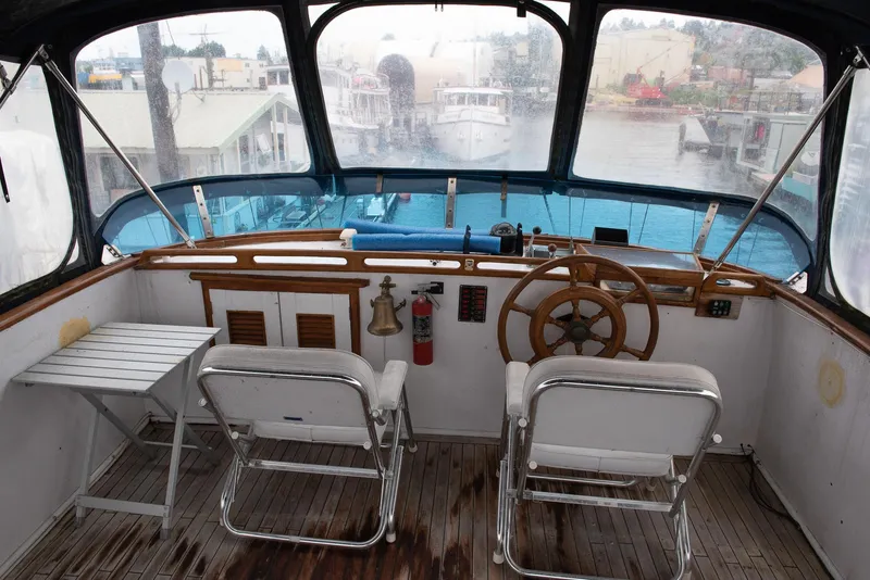 Slide: The Image of 1978 CHB Puget Trawler 37 helm with dual chairs and wooden steering wheel. - 2